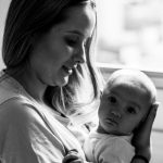 woman in white shirt carrying baby in grayscale photography