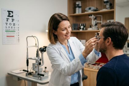 Opticienne examinant la vue d'un patient dans un cabinet ophtalmologique moderne avec instruments optiques